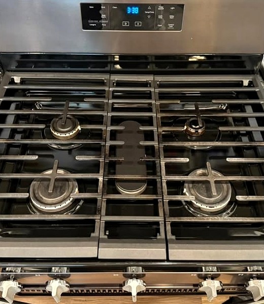 A gas stovetop after an oven add-on: black grates, polished cooktop, clean control panel.